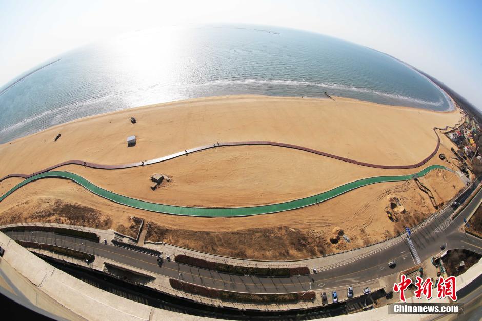 3月13日，秦皇島萬(wàn)米臨海沙灘木棧道。據(jù)了解，該木棧道全長(zhǎng)約4200米，與北戴河區(qū)原有的7500米木棧道對(duì)接后全線(xiàn)總長(zhǎng)度1.17萬(wàn)米，整個(gè)木棧道東起秦皇島體育基地游船碼頭，西至北戴河濕地公園，呈波浪形蜿蜒10.4公里海岸線(xiàn)。 中新社發(fā) 曹建雄 攝 CNSPHOTO